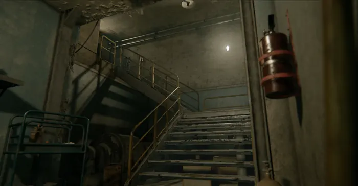 Concrete bunker stairwell with hanging cable lamp and service rails