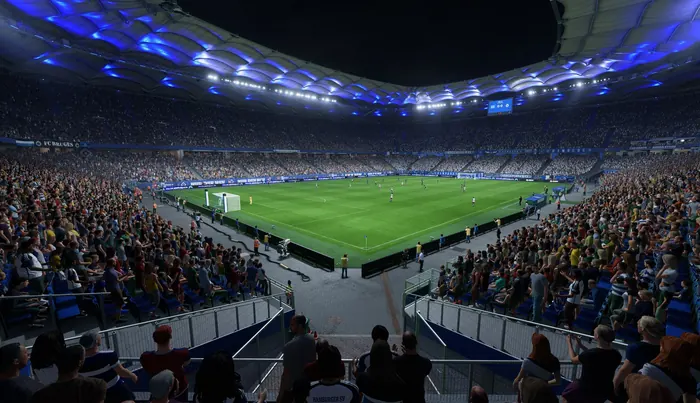 Packed football stadium at night under blue roof lighting