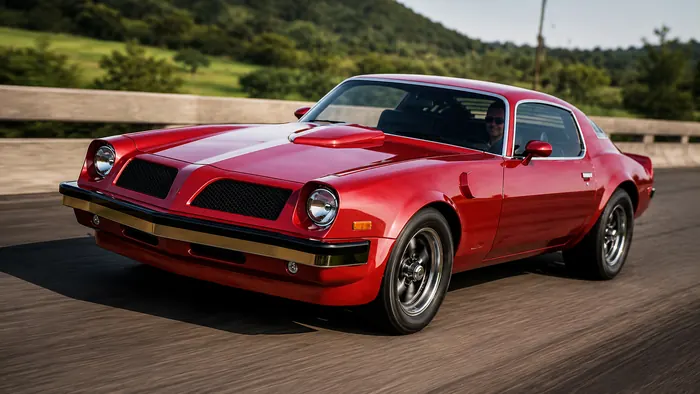 Red 1970s muscle car driving a hillside road, photoreal render